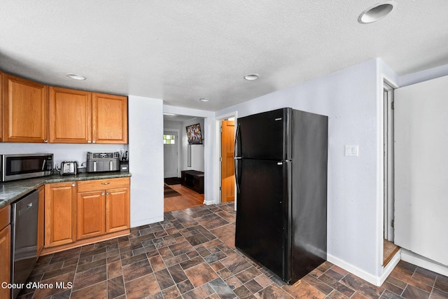 1901 E Pennsylvania Ave, Coeur Dalene, ID 83814 - kitchen with appliances with stainless steel finishes, dark countertops, brown cabinets, a textured ceiling, and stone finish flooring