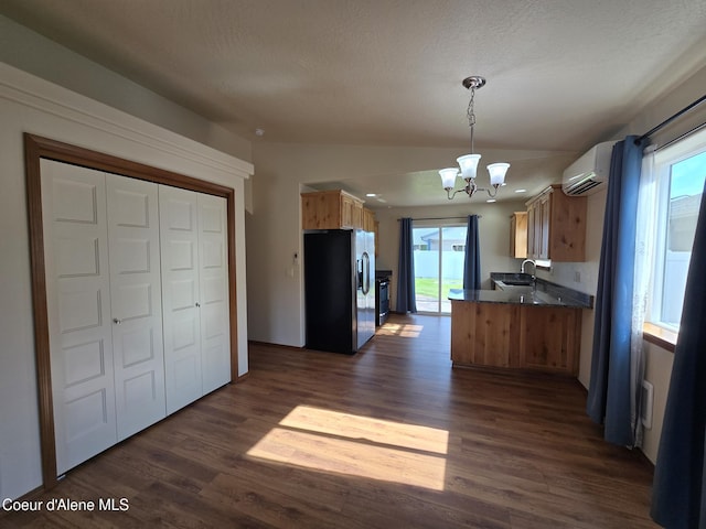 8706 W Sawtooth St, Rathdrum, ID 83858 - kitchen with stainless steel fridge with ice dispenser, a chandelier, dark wood finished floors, a wall mounted AC, and stove