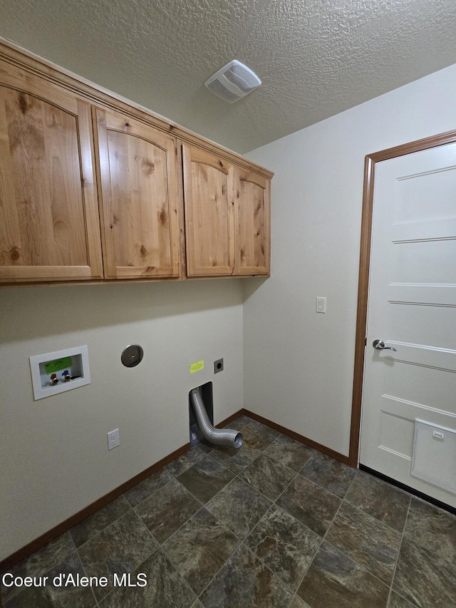 8706 W Sawtooth St, Rathdrum, ID 83858 - laundry area with cabinet space, washer hookup, electric dryer hookup, a textured ceiling, and dark stone finish floors