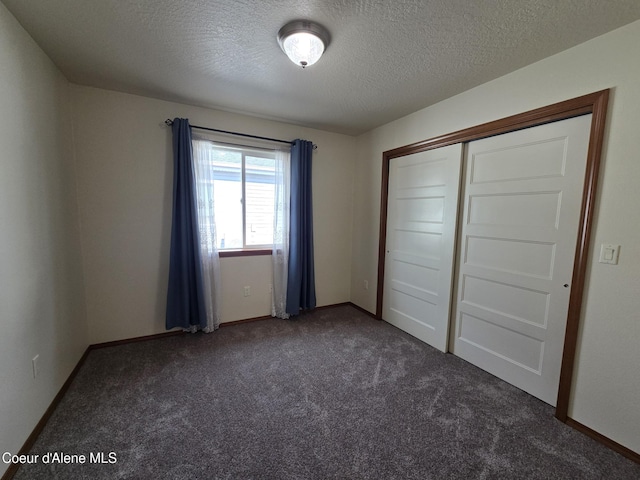 8706 W Sawtooth St, Rathdrum, ID 83858 - unfurnished bedroom featuring dark colored carpet, a textured ceiling, and a closet