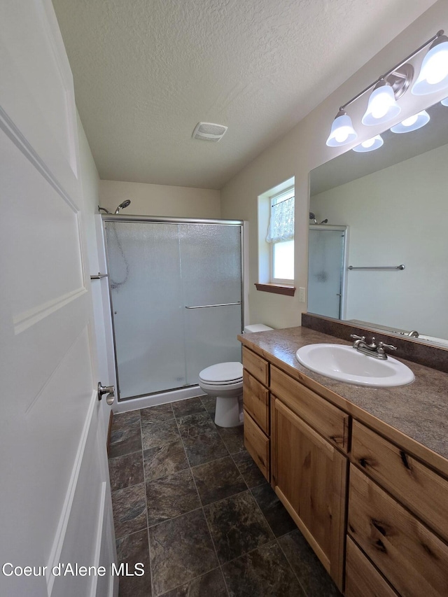 8706 W Sawtooth St, Rathdrum, ID 83858 - full bath with vanity, a stall shower, a textured ceiling, and stone finish floors