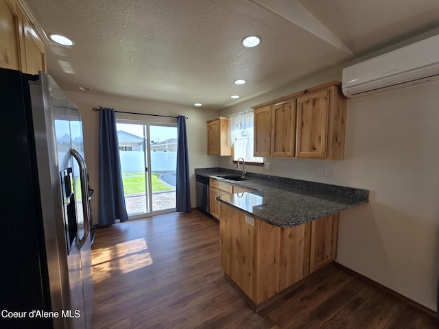 8706 W Sawtooth St, Rathdrum, ID 83858 - kitchen featuring appliances with stainless steel finishes, a wall mounted AC, a peninsula, dark wood finished floors, and a textured ceiling