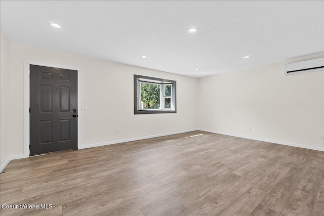 1038 N 15th St, Coeur Dalene, ID 83814 - unfurnished room with a wall unit AC, wood finished floors, recessed lighting, and a textured ceiling
