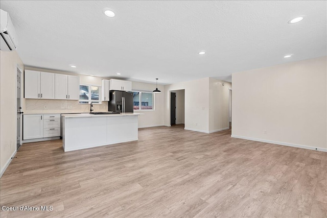 1038 N 15th St, Coeur Dalene, ID 83814 - kitchen with refrigerator with ice dispenser, open floor plan, light wood-style flooring, white cabinetry, and light countertops