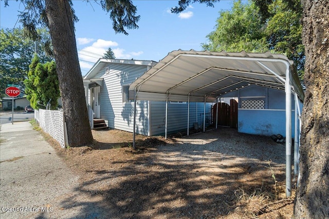 1038 N 15th St, Coeur Dalene, ID 83814 - view of parking / parking lot featuring a carport and dirt driveway