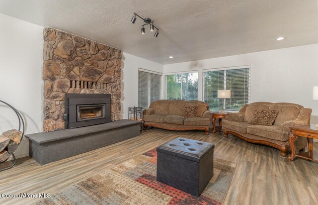 6531 Tannenbaum Cir, Bonners Ferry, ID 83805 - living room with wood finished floors, a textured ceiling, a fireplace, and recessed lighting