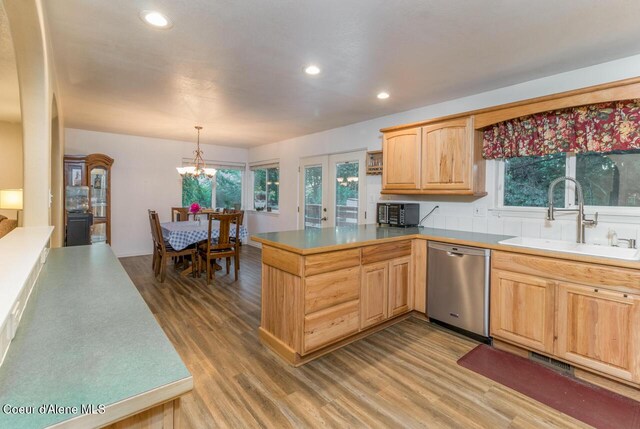 6531 Tannenbaum Cir, Bonners Ferry, ID 83805 - kitchen featuring stainless steel dishwasher, light brown cabinets, wood finished floors, a peninsula, and a chandelier