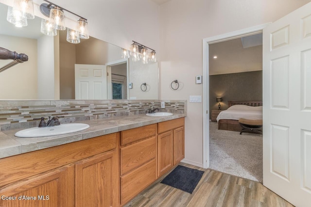 6531 Tannenbaum Cir, Bonners Ferry, ID 83805 - ensuite bathroom featuring double vanity, wood finished floors, and tasteful backsplash