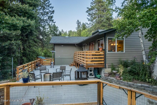 6531 Tannenbaum Cir, Bonners Ferry, ID 83805 - back of house with a wooden deck and a patio