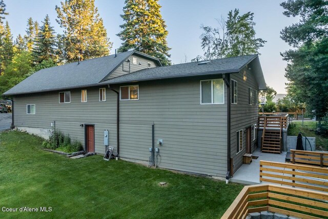 6531 Tannenbaum Cir, Bonners Ferry, ID 83805 - view of side of property featuring stairs, a lawn, roof with shingles, and a wooden deck