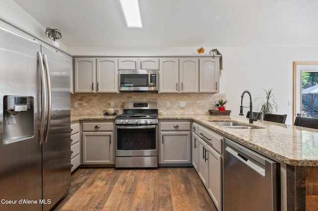 8562 N Audubon Dr, Hayden, ID 83835 - kitchen featuring stainless steel appliances, a peninsula, backsplash, and dark wood-type flooring