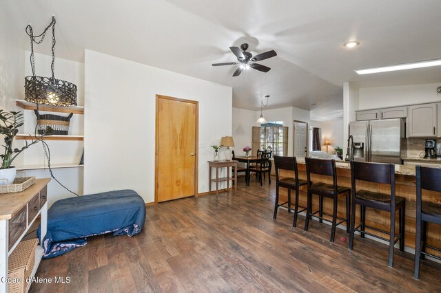 8562 N Audubon Dr, Hayden, ID 83835 - kitchen featuring stainless steel refrigerator with ice dispenser, lofted ceiling, a kitchen bar, a ceiling fan, and gray cabinets