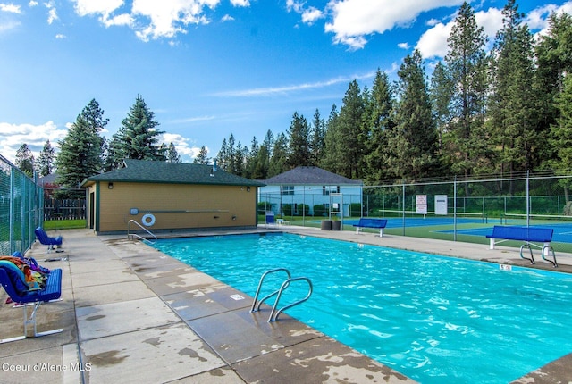 8562 N Audubon Dr, Hayden, ID 83835 - community pool with a tennis court and view of scattered trees