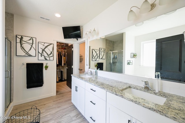 5987 W Quinn Way, Rathdrum, ID 83858 - full bathroom with a stall shower, a spacious closet, double vanity, and wood finished floors