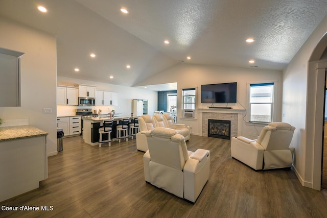 5987 W Quinn Way, Rathdrum, ID 83858 - living room featuring a fireplace, lofted ceiling, dark wood-style flooring, recessed lighting, and a textured ceiling