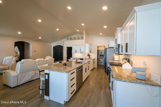 5987 W Quinn Way, Rathdrum, ID 83858 - kitchen featuring appliances with stainless steel finishes, open floor plan, a breakfast bar area, dark wood-style floors, and lofted ceiling