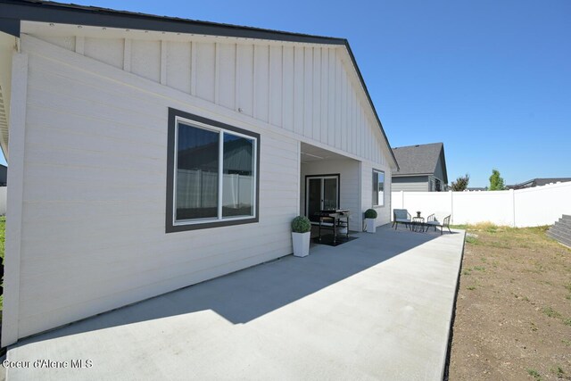 5987 W Quinn Way, Rathdrum, ID 83858 - rear view of house featuring board and batten siding and a patio area