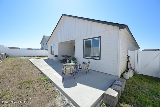 5987 W Quinn Way, Rathdrum, ID 83858 - rear view of property with board and batten siding, a fenced backyard, a patio, and a gate