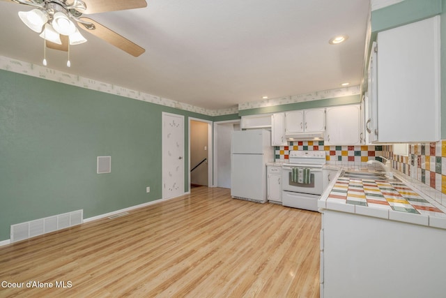 1502 N Melrose St, Coeur Dalene, ID 83814 - kitchen with white appliances, tile counters, light wood-type flooring, decorative backsplash, and white cabinetry