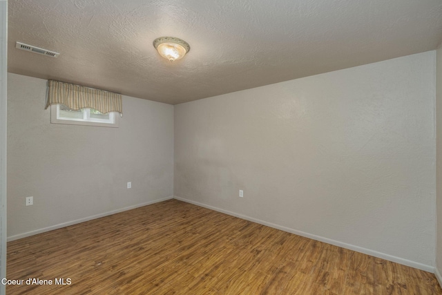 1502 N Melrose St, Coeur Dalene, ID 83814 - unfurnished room featuring wood finished floors and a textured ceiling