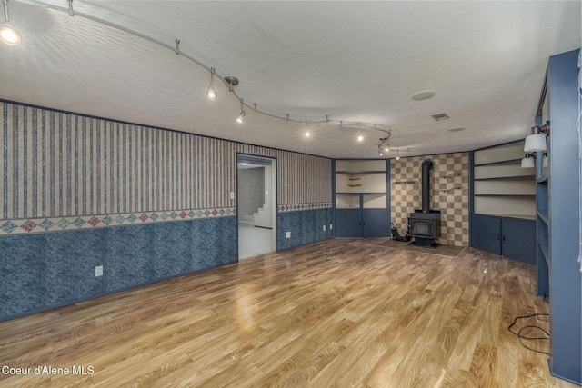 1502 N Melrose St, Coeur Dalene, ID 83814 - unfurnished living room with wallpapered walls, wood finished floors, and a wood stove