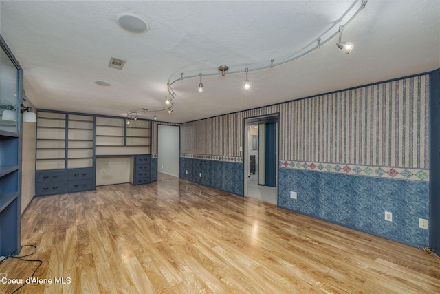 1502 N Melrose St, Coeur Dalene, ID 83814 - unfurnished room with wallpapered walls, wood finished floors, and a textured ceiling