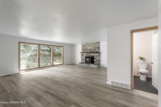 4206 W Appaloosa Rd, Coeur Dalene, ID 83815 - unfurnished living room featuring wood finished floors and a stone fireplace