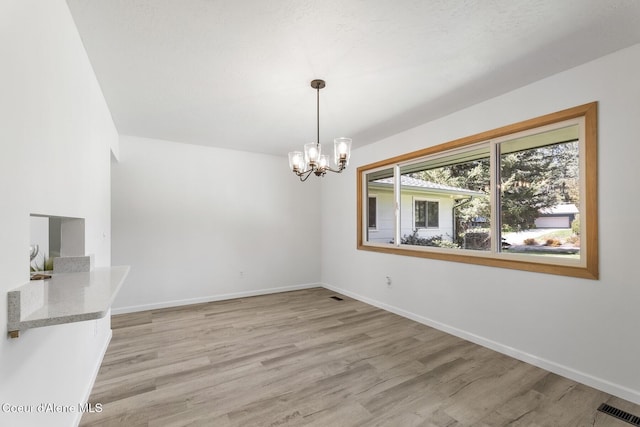 4206 W Appaloosa Rd, Coeur Dalene, ID 83815 - unfurnished dining area with light wood finished floors and a chandelier