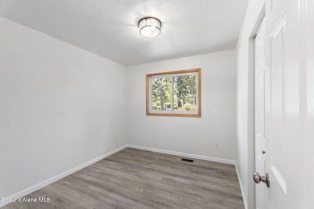 4206 W Appaloosa Rd, Coeur Dalene, ID 83815 - empty room with wood finished floors and a textured ceiling