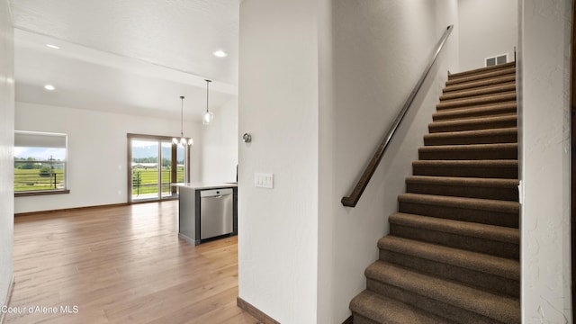 3306 Goodman Dr, Sandpoint, ID 83864 - stairway featuring wood finished floors, a chandelier, and recessed lighting