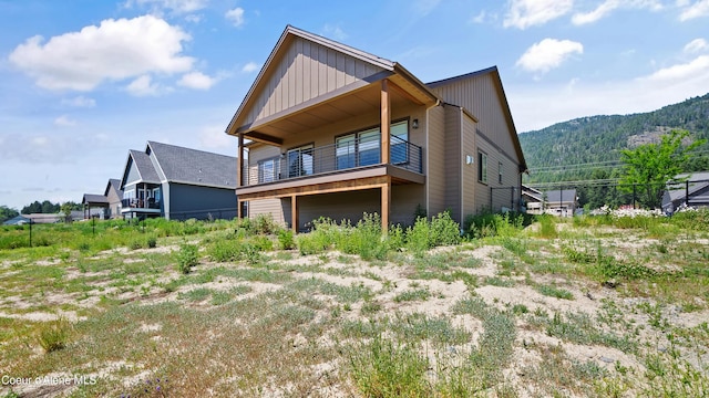 3306 Goodman Dr, Sandpoint, ID 83864 - back of property with board and batten siding, a balcony, and a mountain view