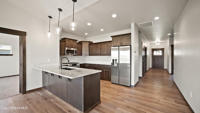 3306 Goodman Dr, Sandpoint, ID 83864 - kitchen with appliances with stainless steel finishes, a peninsula, dark brown cabinetry, light wood-type flooring, and recessed lighting