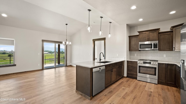 3306 Goodman Dr, Sandpoint, ID 83864 - kitchen with stainless steel appliances, a peninsula, dark brown cabinets, light countertops, and decorative backsplash