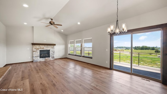 3306 Goodman Dr, Sandpoint, ID 83864 - unfurnished living room with a ceiling fan, a chandelier, wood finished floors, recessed lighting, and a stone fireplace