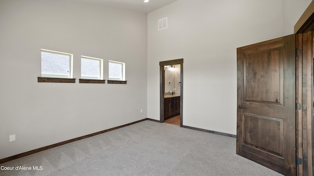 3306 Goodman Dr, Sandpoint, ID 83864 - unfurnished bedroom featuring light colored carpet, a towering ceiling, and connected bathroom