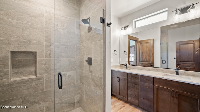 3306 Goodman Dr, Sandpoint, ID 83864 - bathroom with double vanity, a shower stall, and wood finished floors