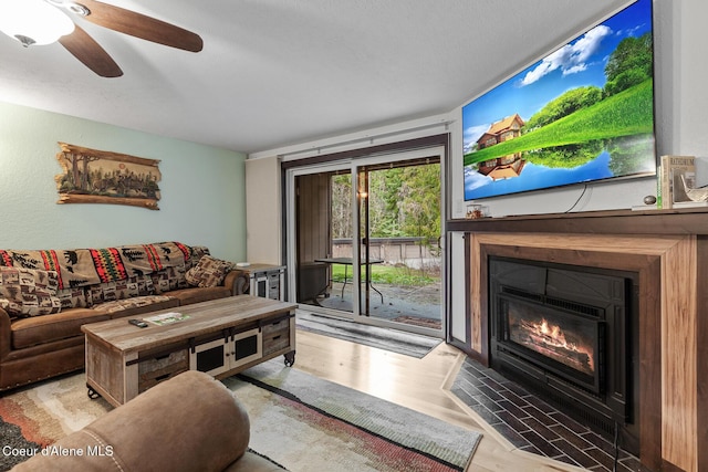 5421 W Fairway Ln # 23, Rathdrum, ID 83858 - living room featuring a ceiling fan, wood finished floors, and a fireplace with flush hearth
