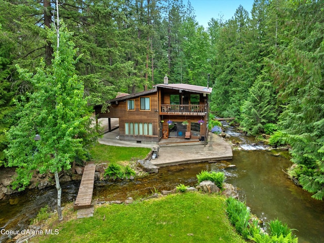 19565 N Goelzer Way, Rathdrum, ID 83858 - rear view of property with a chimney, a patio, a wooded view, and a deck