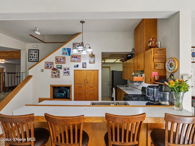 19565 N Goelzer Way, Rathdrum, ID 83858 - kitchen with appliances with stainless steel finishes, ventilation hood, a peninsula, decorative light fixtures, and light countertops