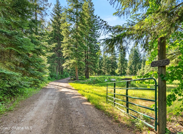 19565 N Goelzer Way, Rathdrum, ID 83858 - view of dirt / gravel road with a wooded view, a gate, and a gated entry