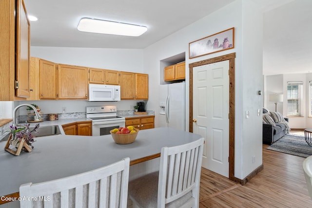 7560 W Sunrise St, Rathdrum, ID 83858 - kitchen with white appliances, lofted ceiling, a peninsula, light wood-style floors, and light countertops