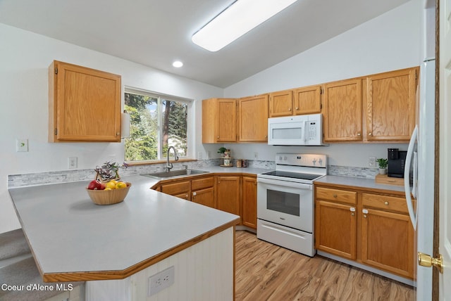7560 W Sunrise St, Rathdrum, ID 83858 - kitchen with white appliances, a peninsula, light countertops, lofted ceiling, and light wood-style floors