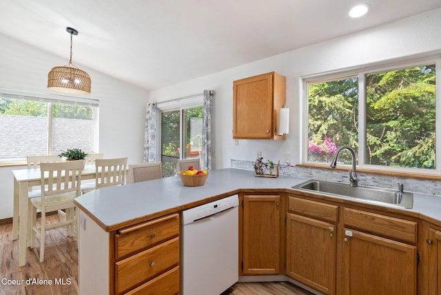7560 W Sunrise St, Rathdrum, ID 83858 - kitchen featuring white dishwasher, vaulted ceiling, a peninsula, light wood-style floors, and light countertops
