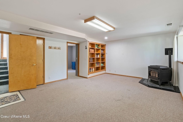 7560 W Sunrise St, Rathdrum, ID 83858 - basement featuring light carpet, stairway, and a wood stove