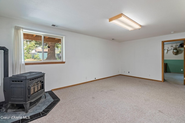 7560 W Sunrise St, Rathdrum, ID 83858 - unfurnished living room featuring a wood stove and carpet