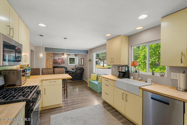 1318 N 10th St, Coeur Dalene, ID 83814 - kitchen with appliances with stainless steel finishes, butcher block counters, cream cabinets, healthy amount of natural light, and recessed lighting
