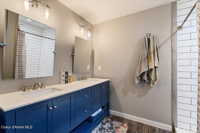 1318 N 10th St, Coeur Dalene, ID 83814 - bathroom featuring wood finished floors, double vanity, and a shower