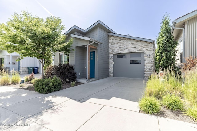 2999 N Casa Ct, Coeur Dalene, ID 83814 - view of front of house featuring stone siding, driveway, and an attached garage