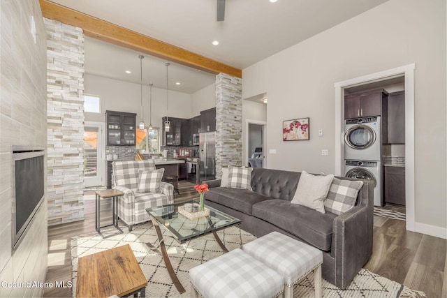2999 N Casa Ct, Coeur Dalene, ID 83814 - living area featuring estacked washer and dryer, wood finished floors, a high ceiling, beam ceiling, and a large fireplace
