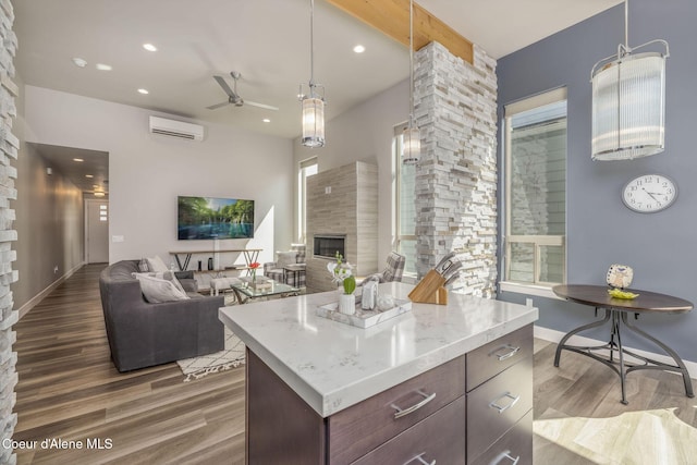 2999 N Casa Ct, Coeur Dalene, ID 83814 - kitchen featuring a wall mounted AC, a ceiling fan, wood finished floors, a fireplace, and recessed lighting